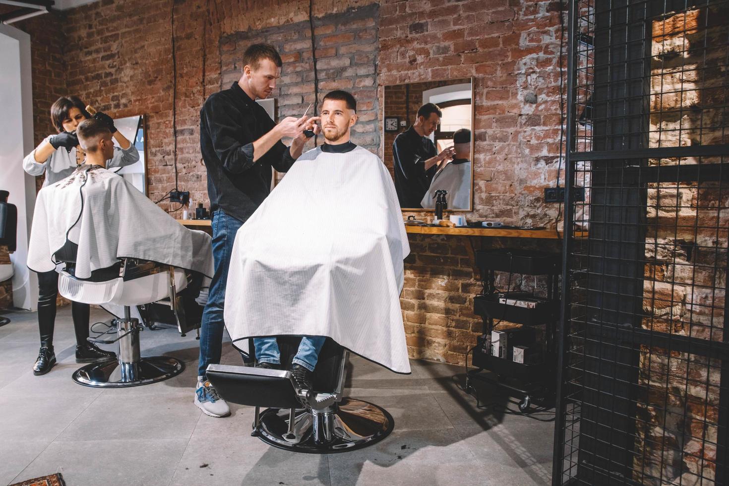 Friseure schneiden ihre Kunden im Friseursalon. Werbe- und Friseurkonzept foto