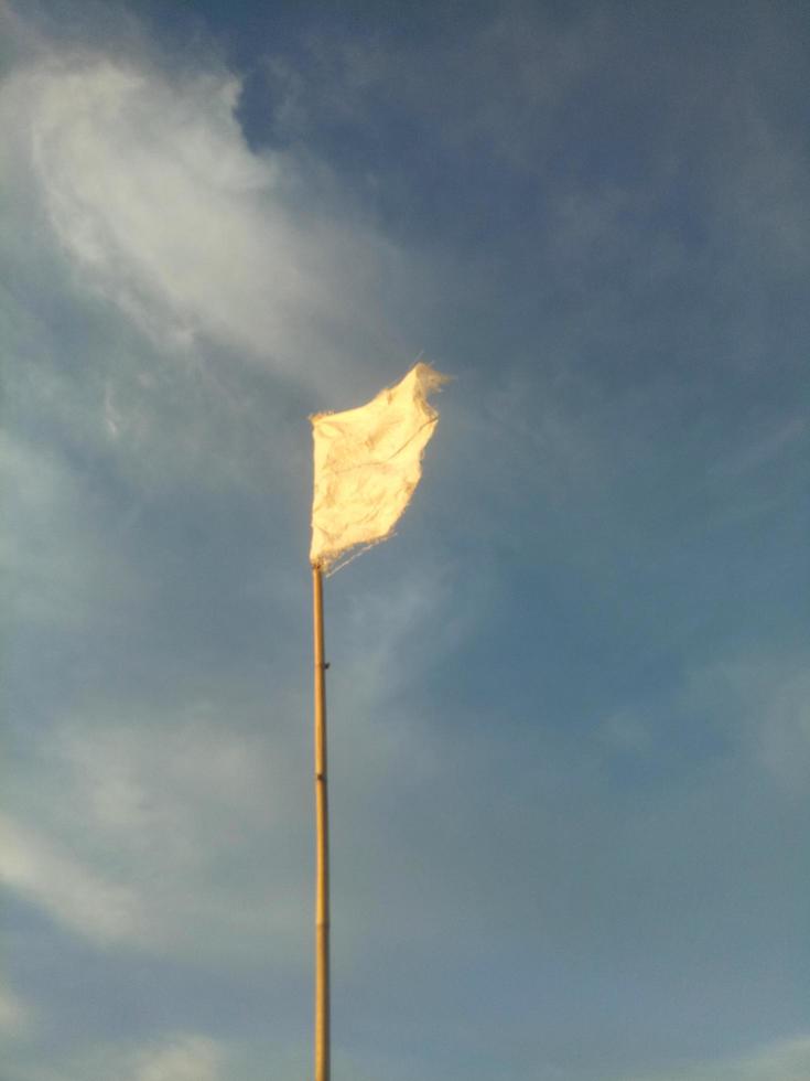 wehende weiße Flagge vor dem Hintergrund des blauen Himmels. foto