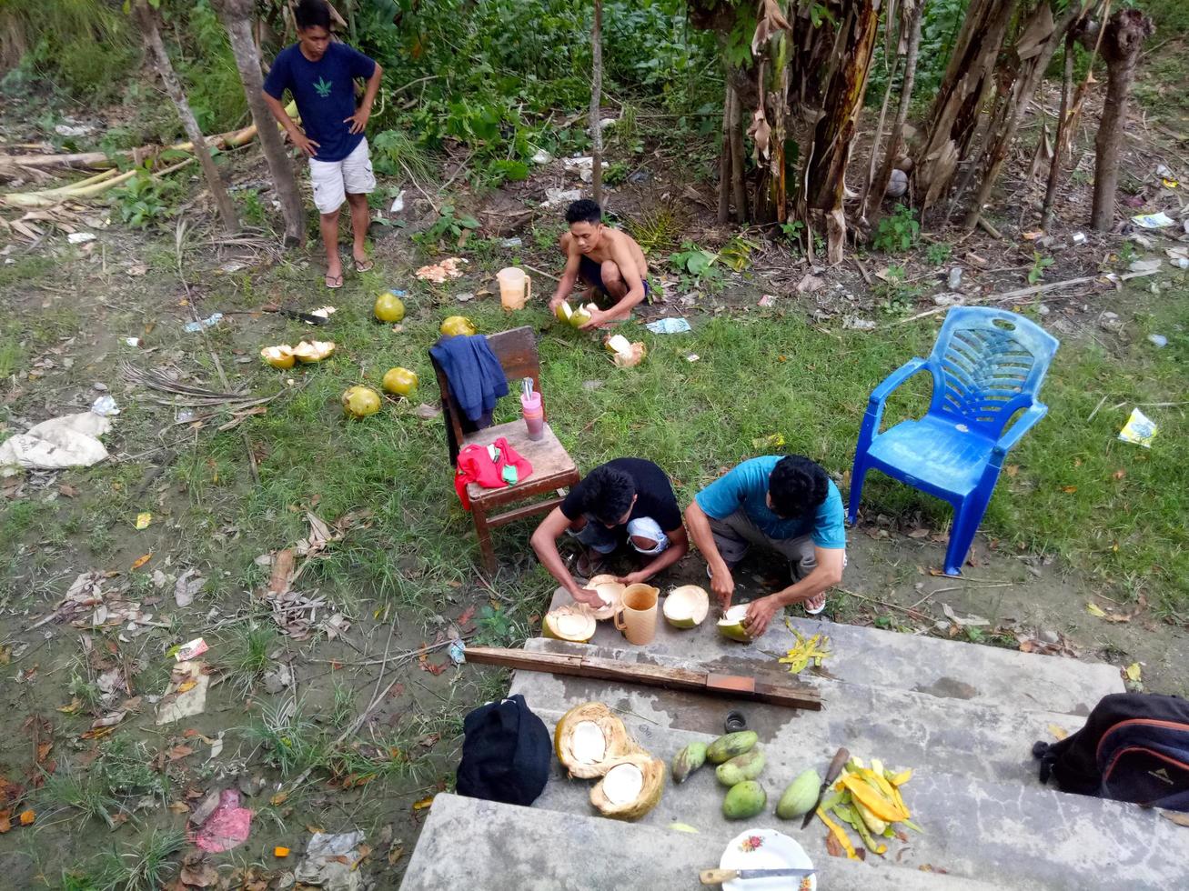 Indonesien, Juli 2021 - eine Gruppe Jugendlicher genießt nachmittags Kokosnüsse im Vorgarten des Hauses foto