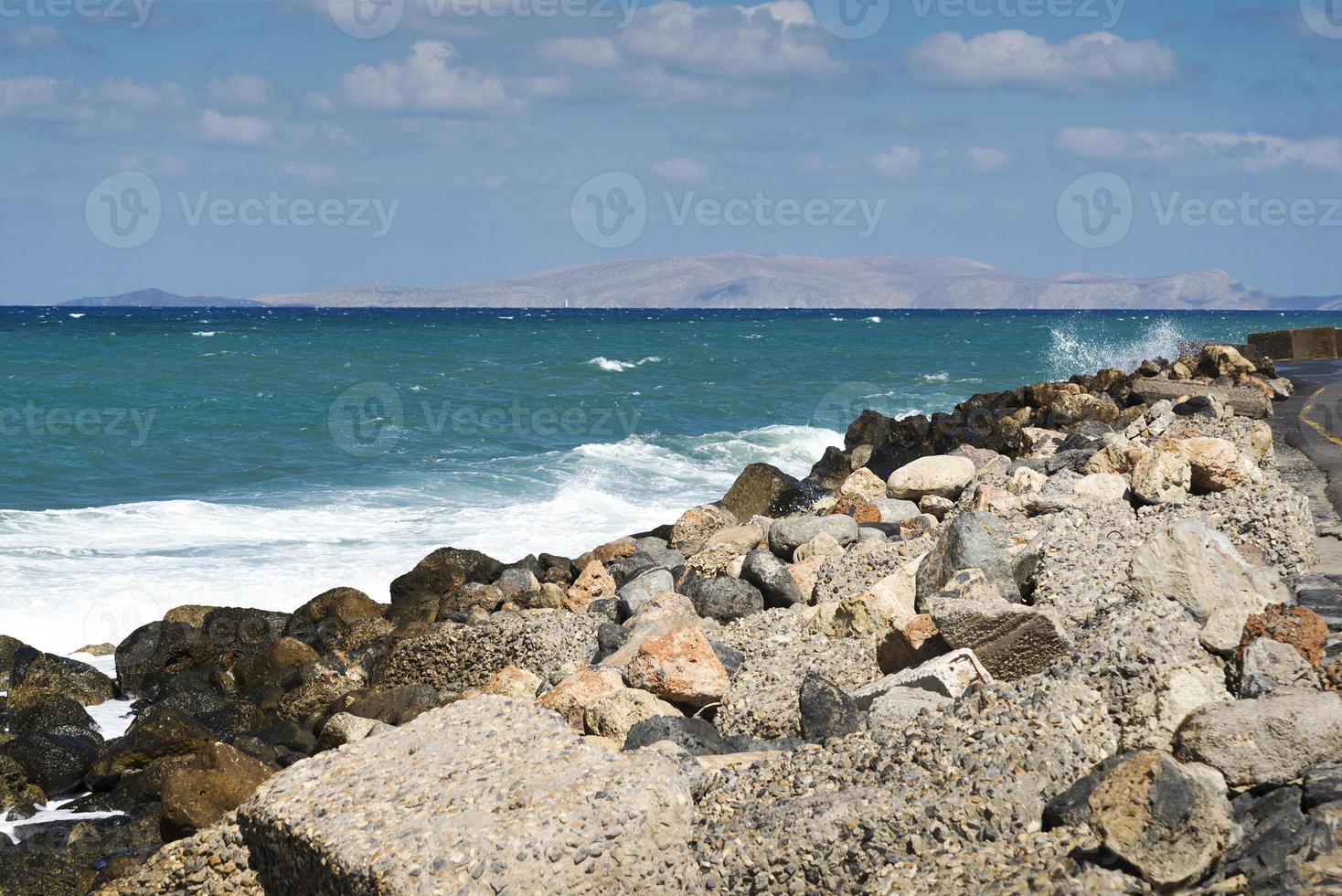 die Wellen brechen an einem steinigen Strand und bilden eine Gischt. Welle und Spritzer am Strand. Wellen, die auf Felsen krachen. foto