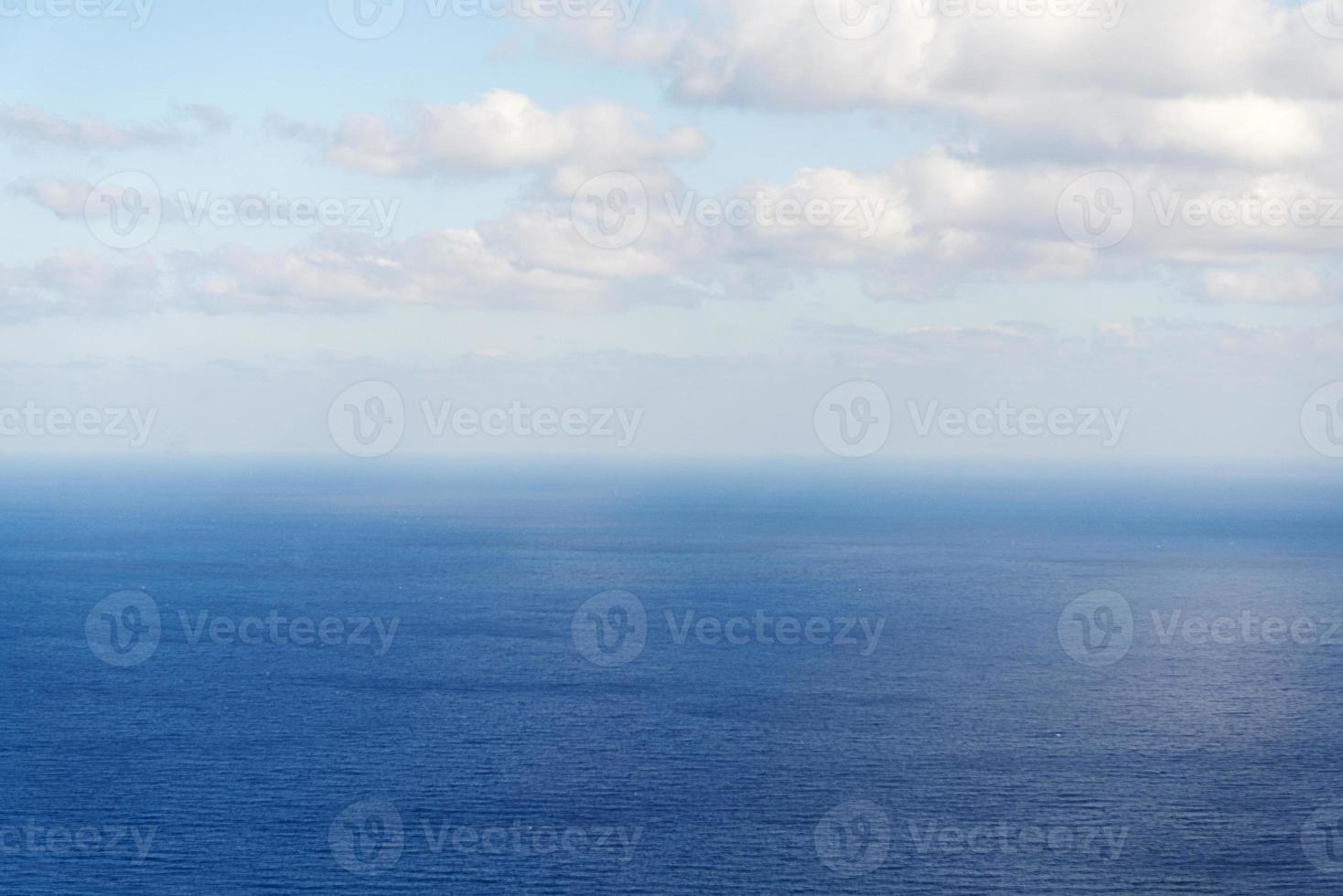 schöne weiße wolken am blauen himmel über ruhigem meer mit sonnenreflexion, bali indonesien. ruhige Meeresharmonie der ruhigen Wasseroberfläche. sonniger Himmel und ruhiger blauer Ozean. foto