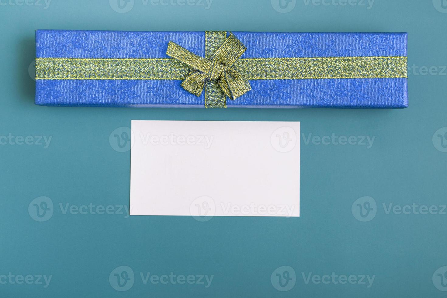 Geschenkbox mit Krawatte und Karte auf türkisfarbenem Hintergrund. Weihnachtsgeschenke Nahaufnahme mit Textfreiraum foto