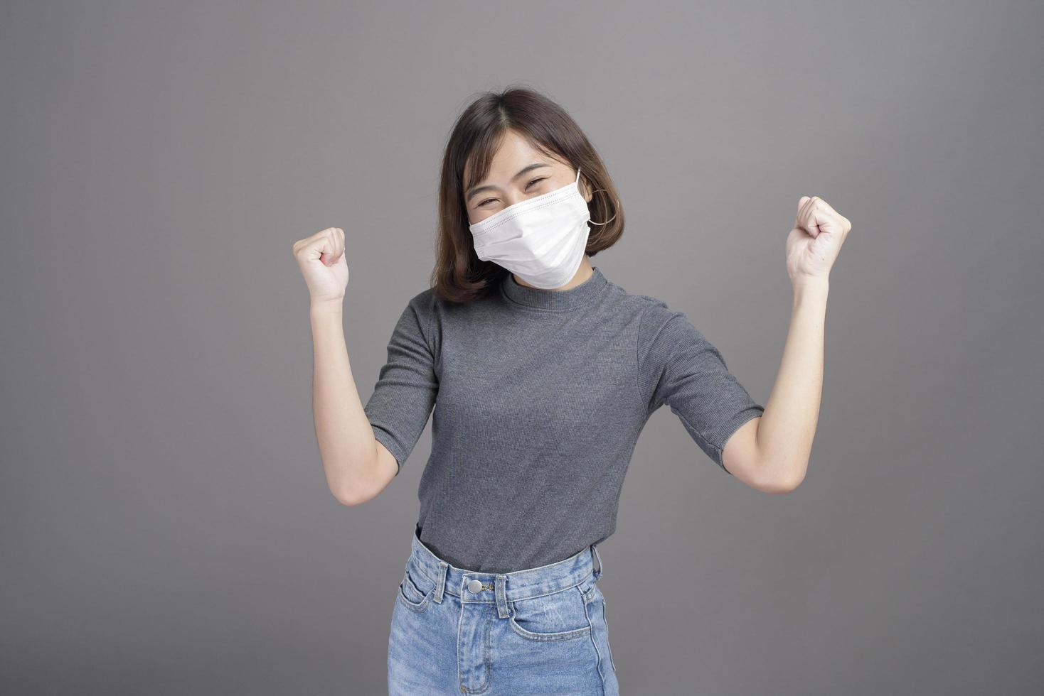 Porträt einer jungen schönen asiatischen Frau, die eine chirurgische Maske über Studiohintergrund trägt, Covid19-Pandemie und Luftverschmutzung foto