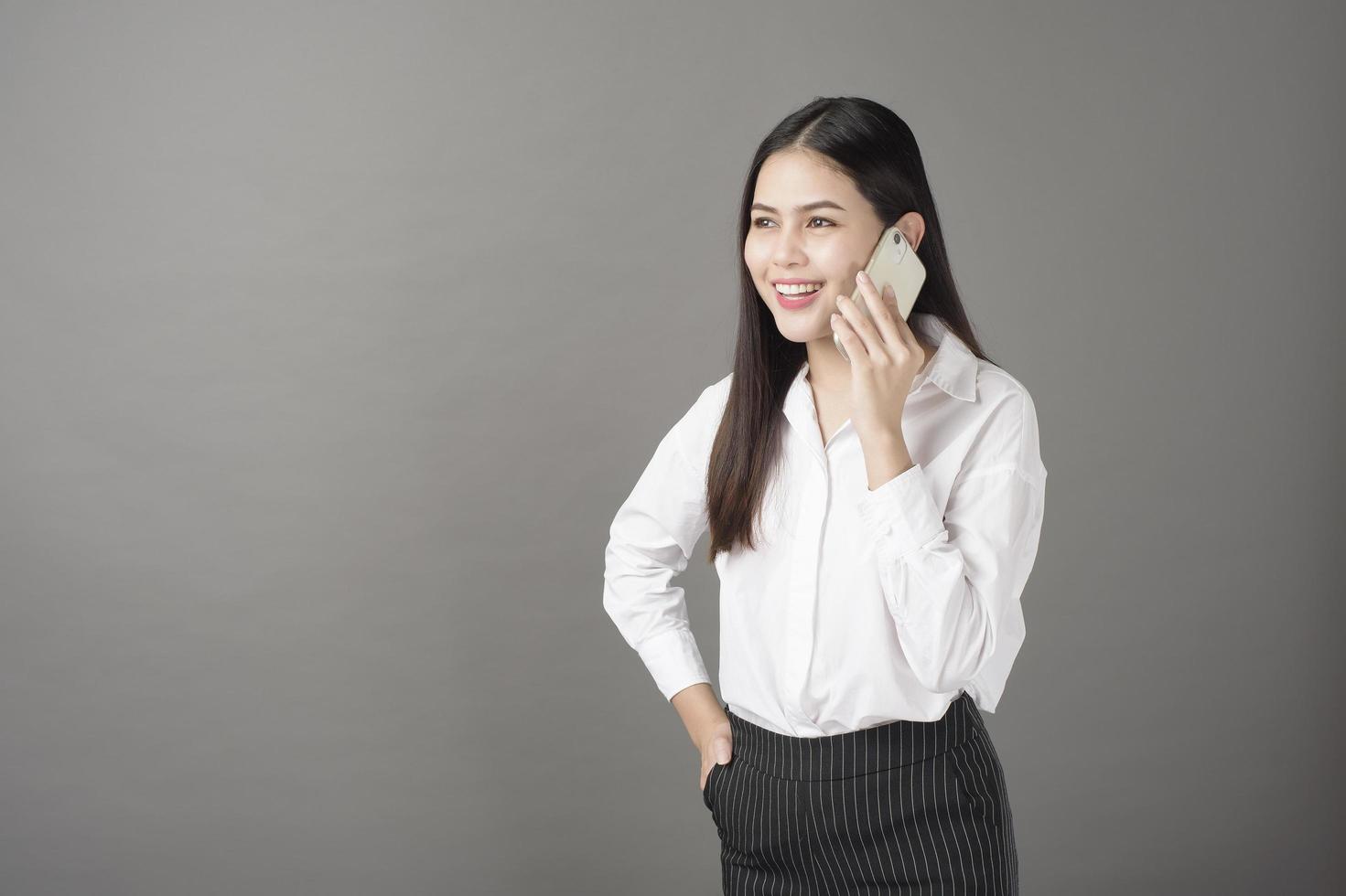 Schöne Frau benutzt Handy im Studio foto