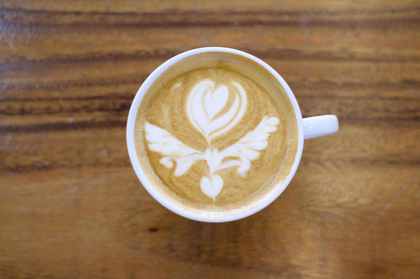 Draufsicht einer Tasse heißer Latte Art auf Holztischhintergrund foto
