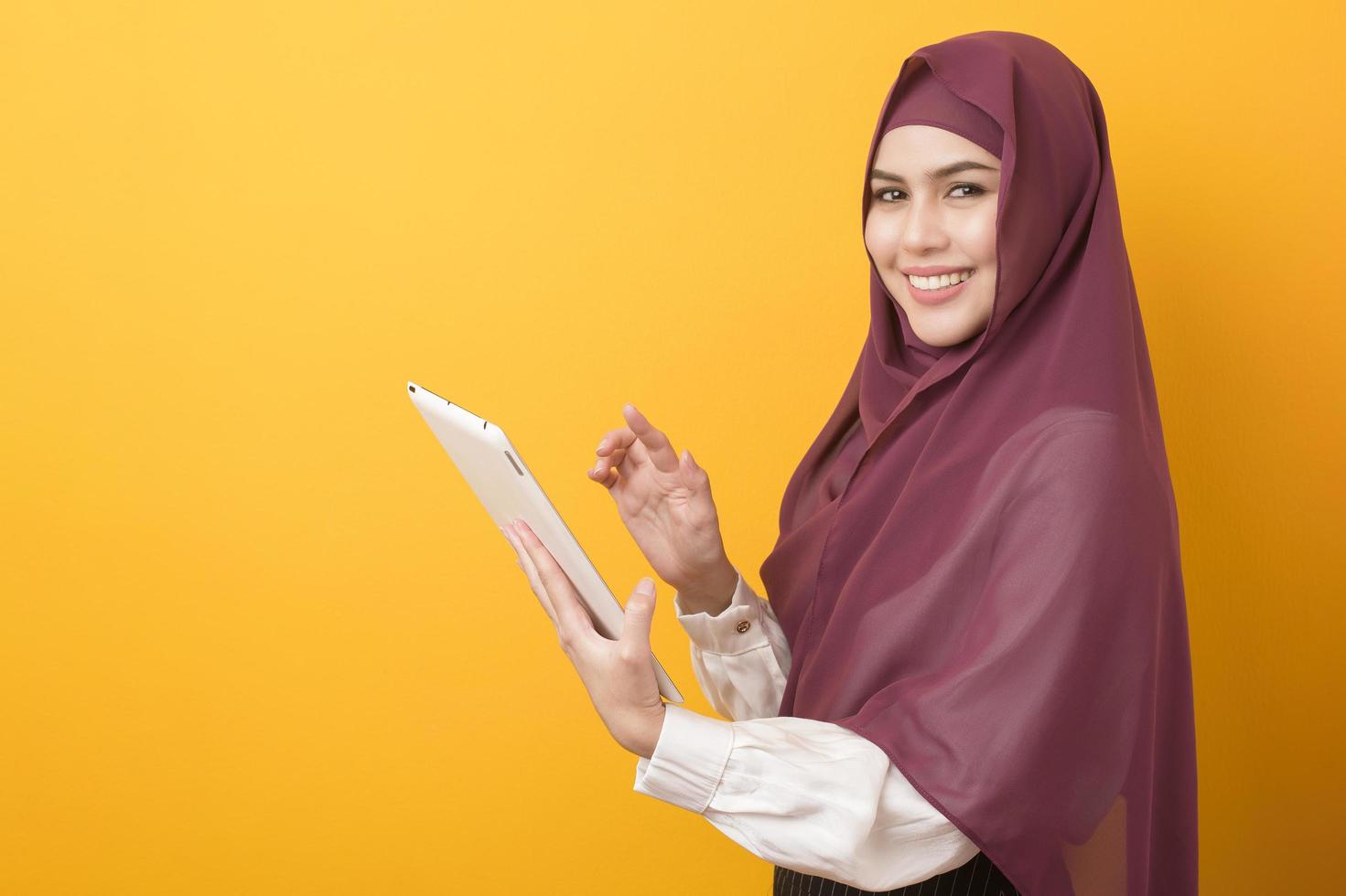 schöner Universitätsstudent mit Hijab-Porträt auf gelbem Hintergrund foto