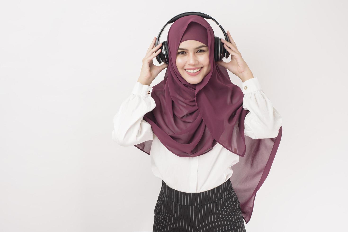 Porträt der schönen Frau mit Hijab ist viel Spaß beim Musikhören auf weißem Hintergrund foto