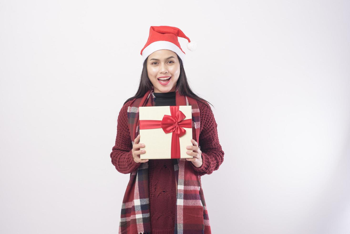 Porträt der jungen lächelnden Frau mit rotem Weihnachtsmann-Hut isolierten weißen Hintergrundstudio. foto