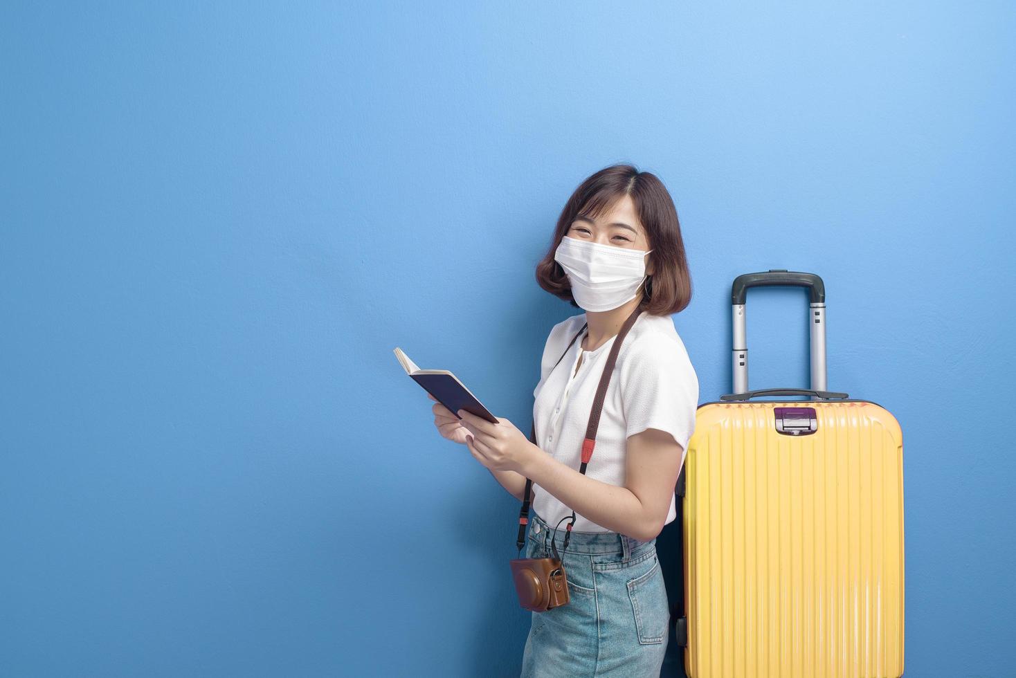 Porträt der jungen Reisendenfrau mit Gesichtsmaske, neues normales Reisekonzept foto