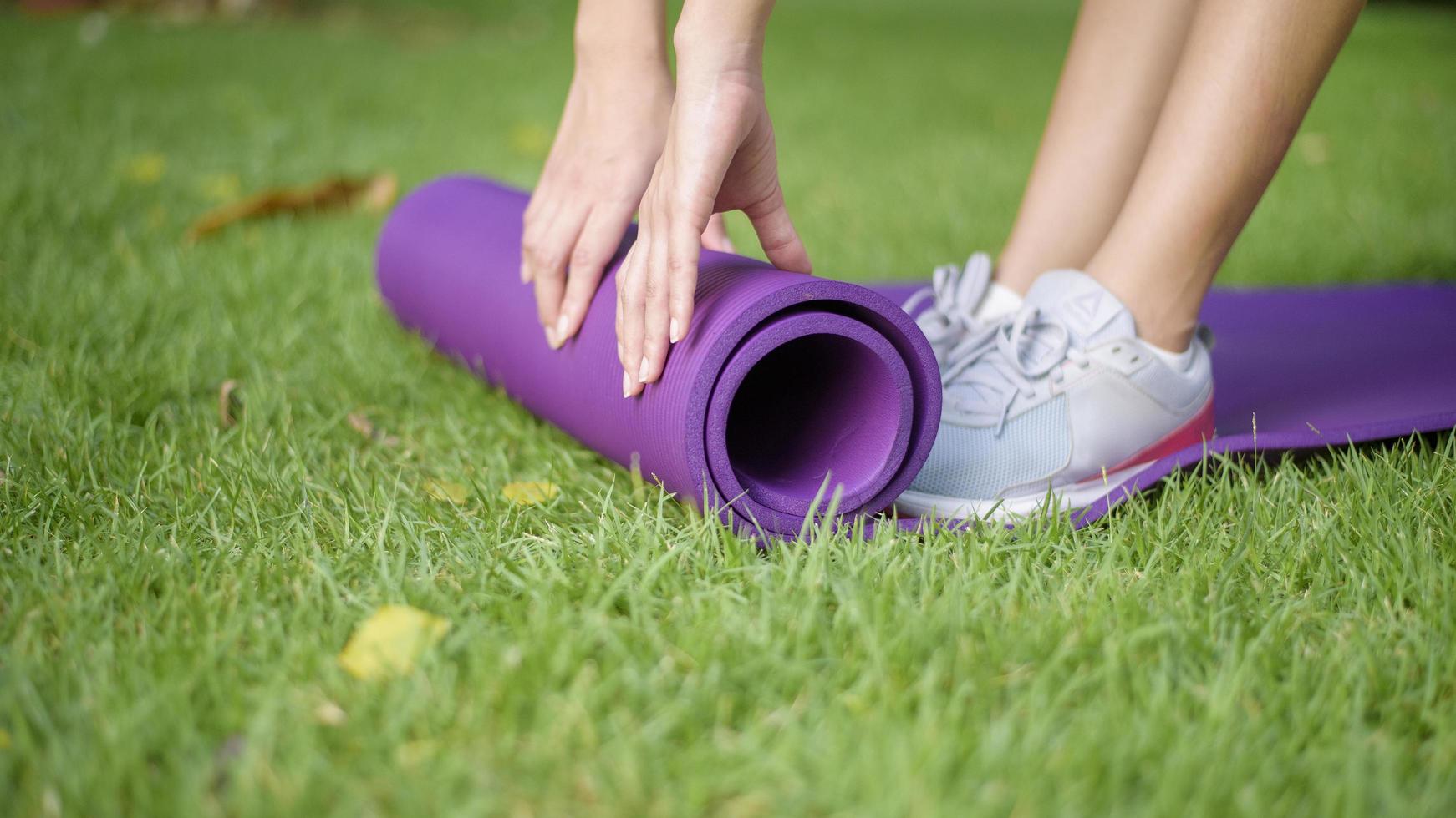 Frau trainiert im Freien mit Gymnastikmatte foto