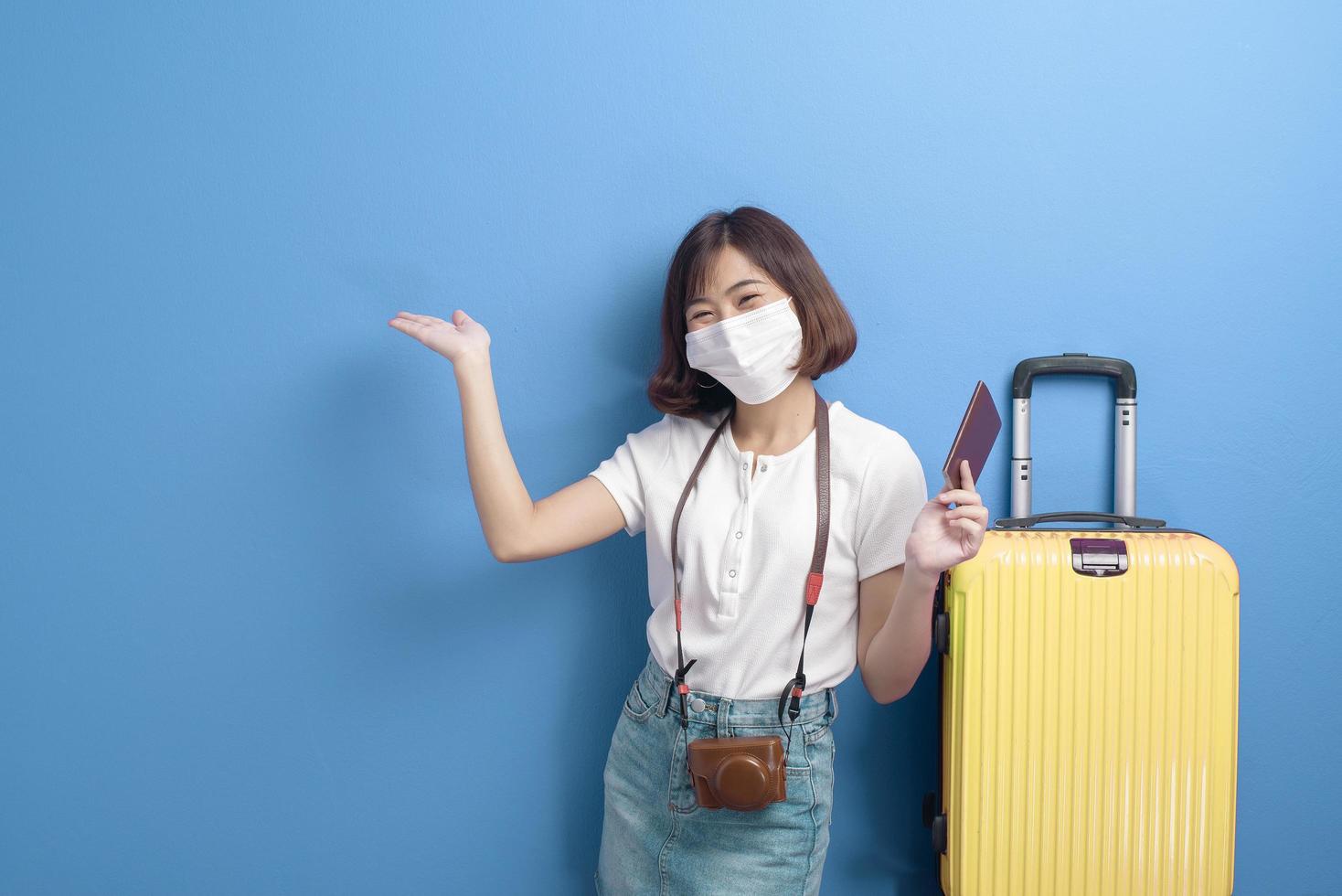 Porträt der jungen Reisendenfrau mit Gesichtsmaske, neues normales Reisekonzept foto