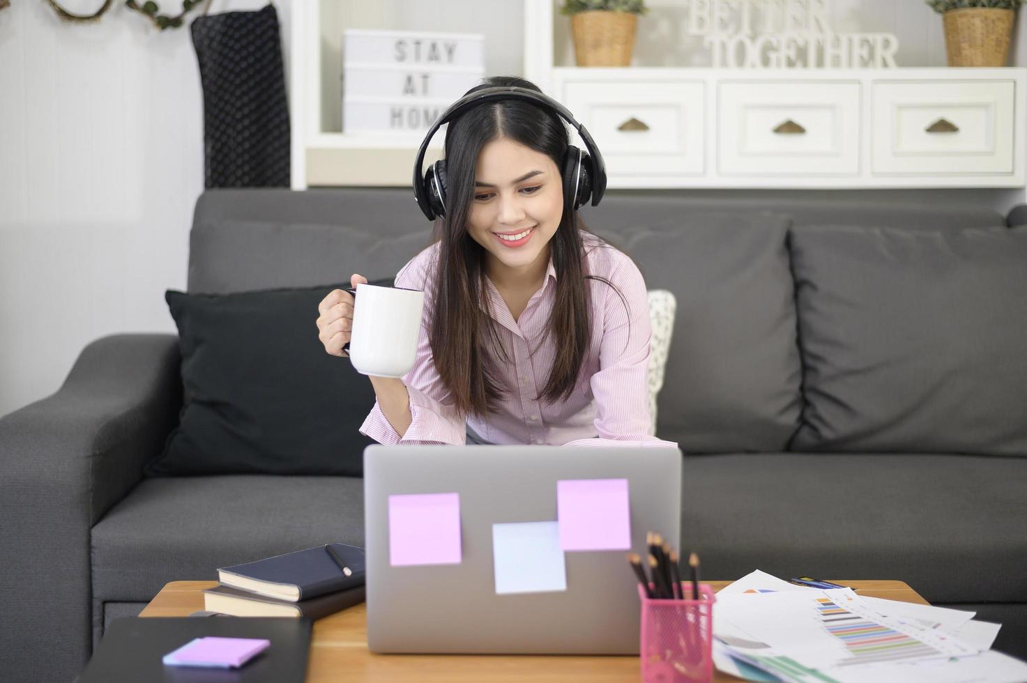 Eine schöne junge Frau, die ein Headset trägt, führt zu Hause eine Videokonferenz über den Computer durch, Geschäftstechnologiekonzept. foto