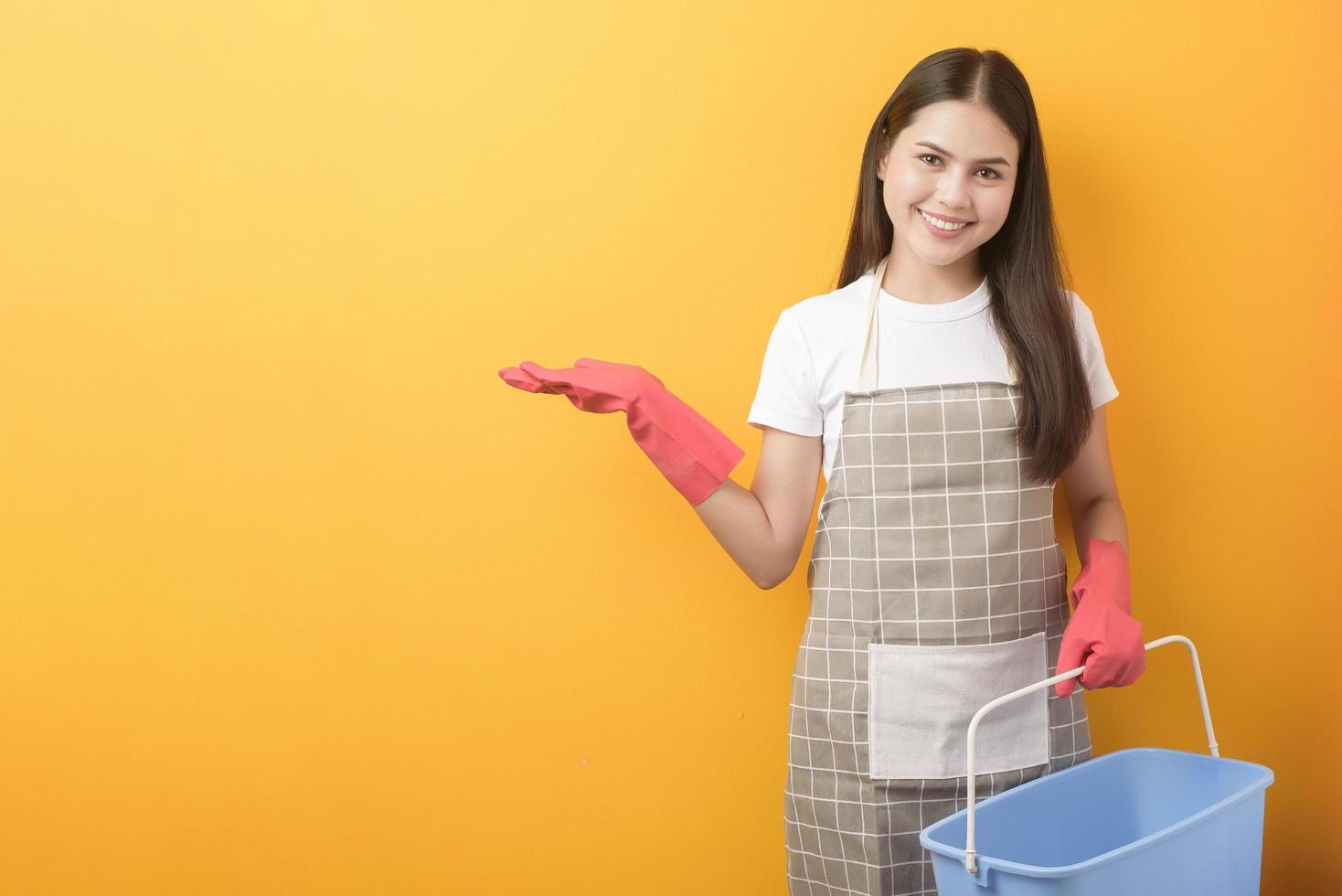 schöne Frau Haushälterin Porträt auf gelbem Hintergrund foto