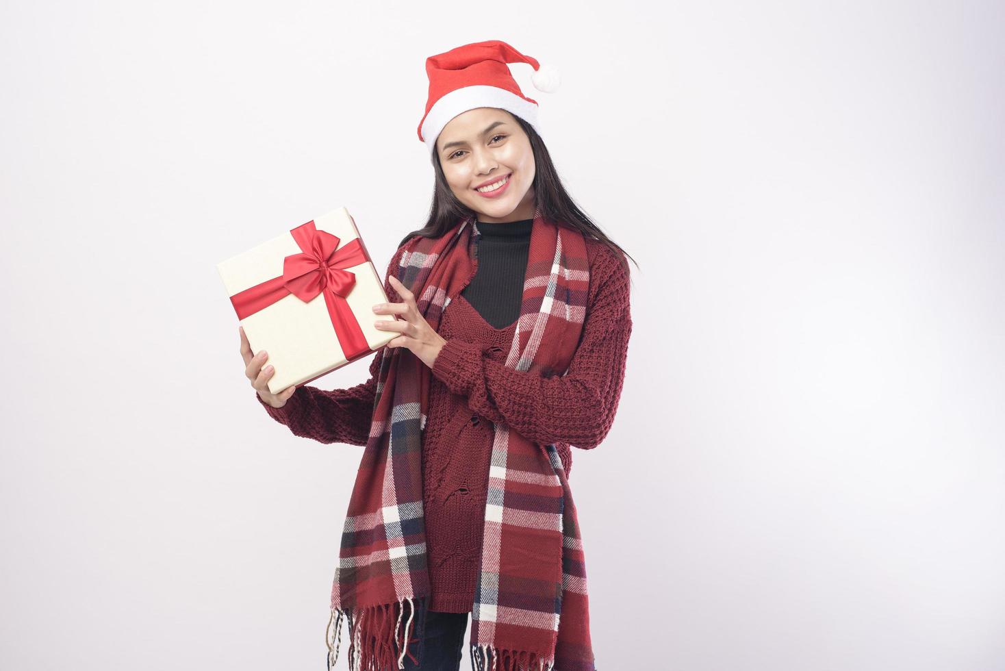 Porträt der jungen lächelnden Frau mit rotem Weihnachtsmann-Hut isolierten weißen Hintergrundstudio. foto