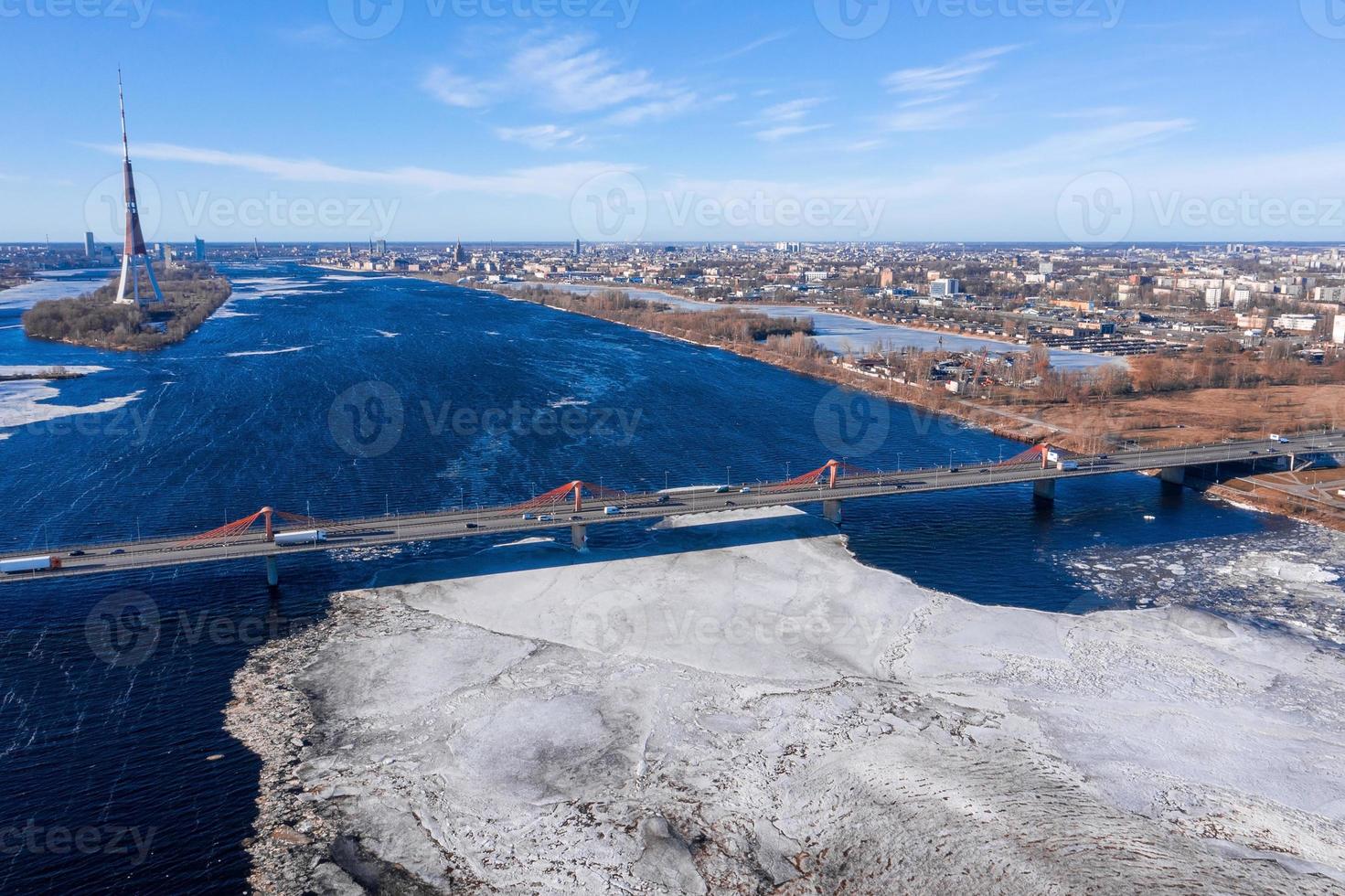 Luftaufnahme der Südbrücke über den Fluss Daugava in Lettland mit einem Eis geformten Mustern, die im Fluss schwimmen. foto