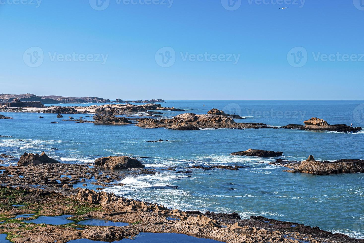 Felsformationen an der Küste im Meer gegen blauen klaren Himmel foto