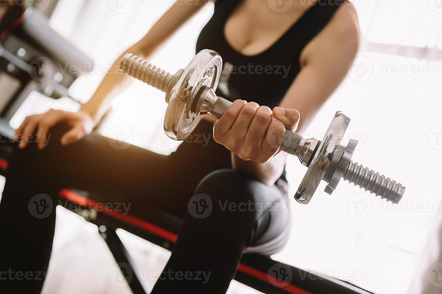 entschlossene Frau, die zu Hause abnimmt und mit Hanteln trainiert. Sport- und Erholungskonzept. schöne Frau foto