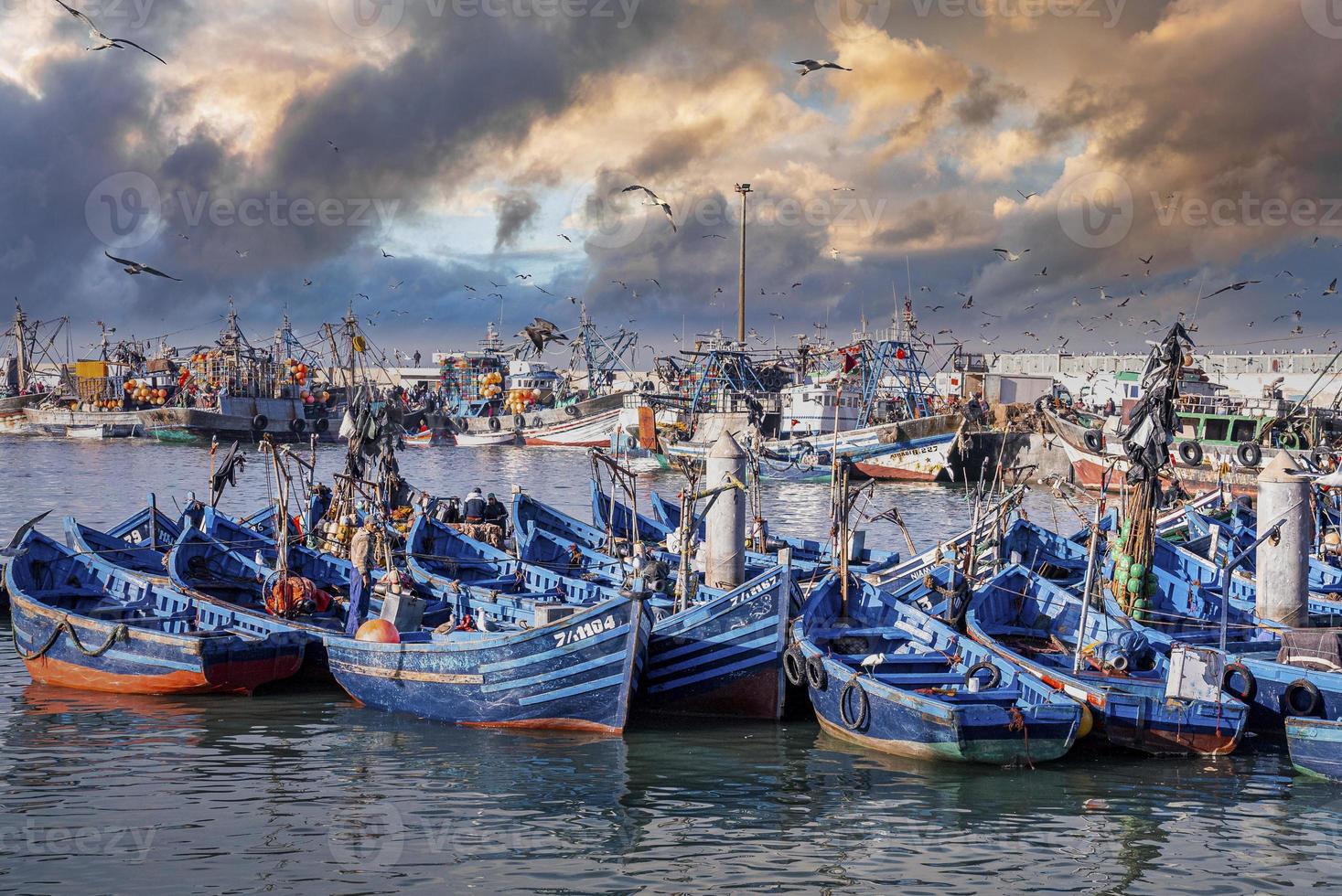 hölzerne Fischerboote verankert am Jachthafen gegen dramatischen bewölkten Himmel foto