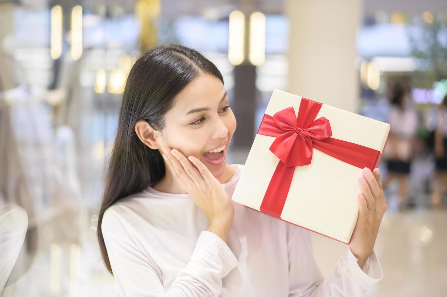 Frau mit einer Geschenkbox im Einkaufszentrum, Thanksgiving und Weihnachtskonzept. foto