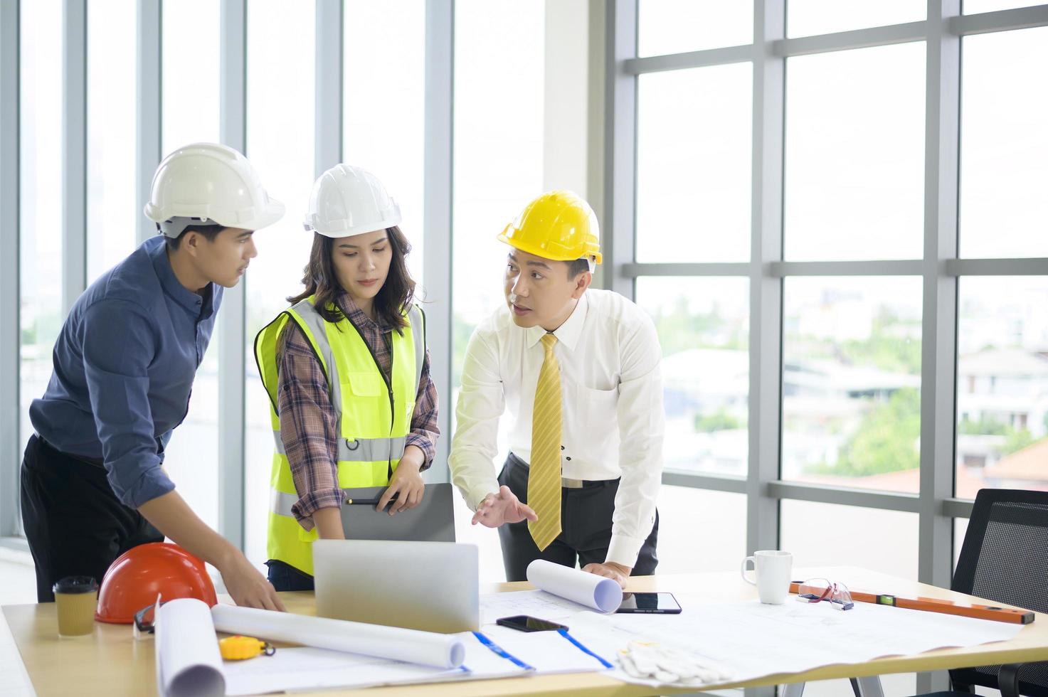 Ingenieure sind analytische Baupläne mit Blaupause im Büro foto