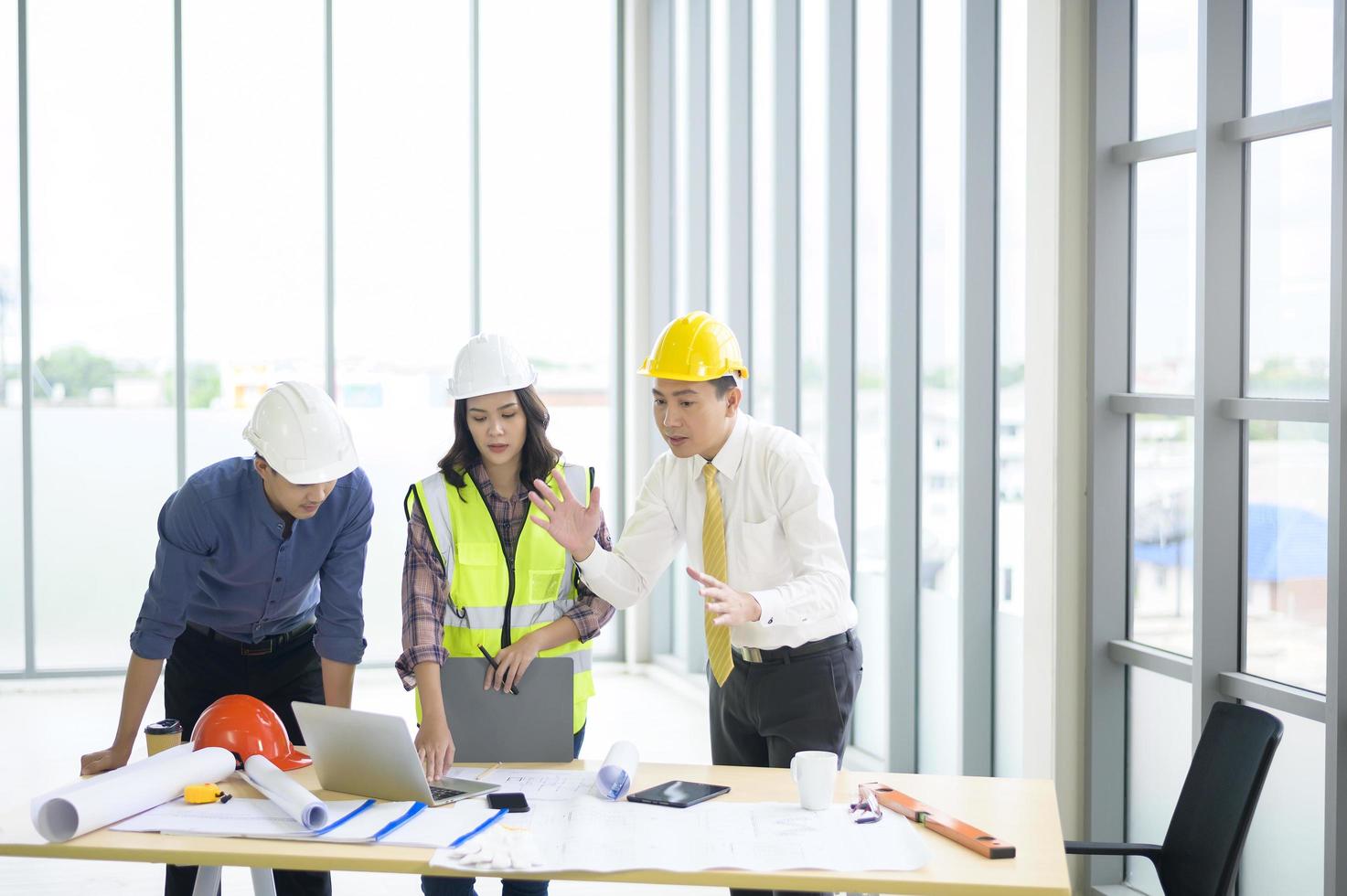 Ingenieure sind analytische Baupläne mit Blaupause im Büro foto