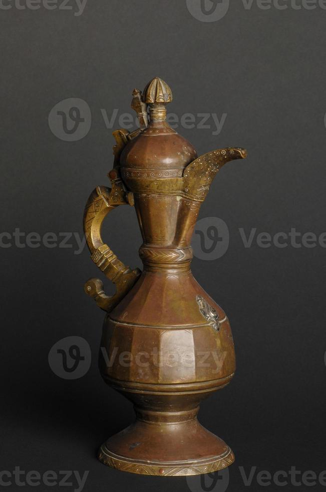 alte orientalische Teekanne aus Metall auf dunklem Hintergrund. antikes Bronzegeschirr foto