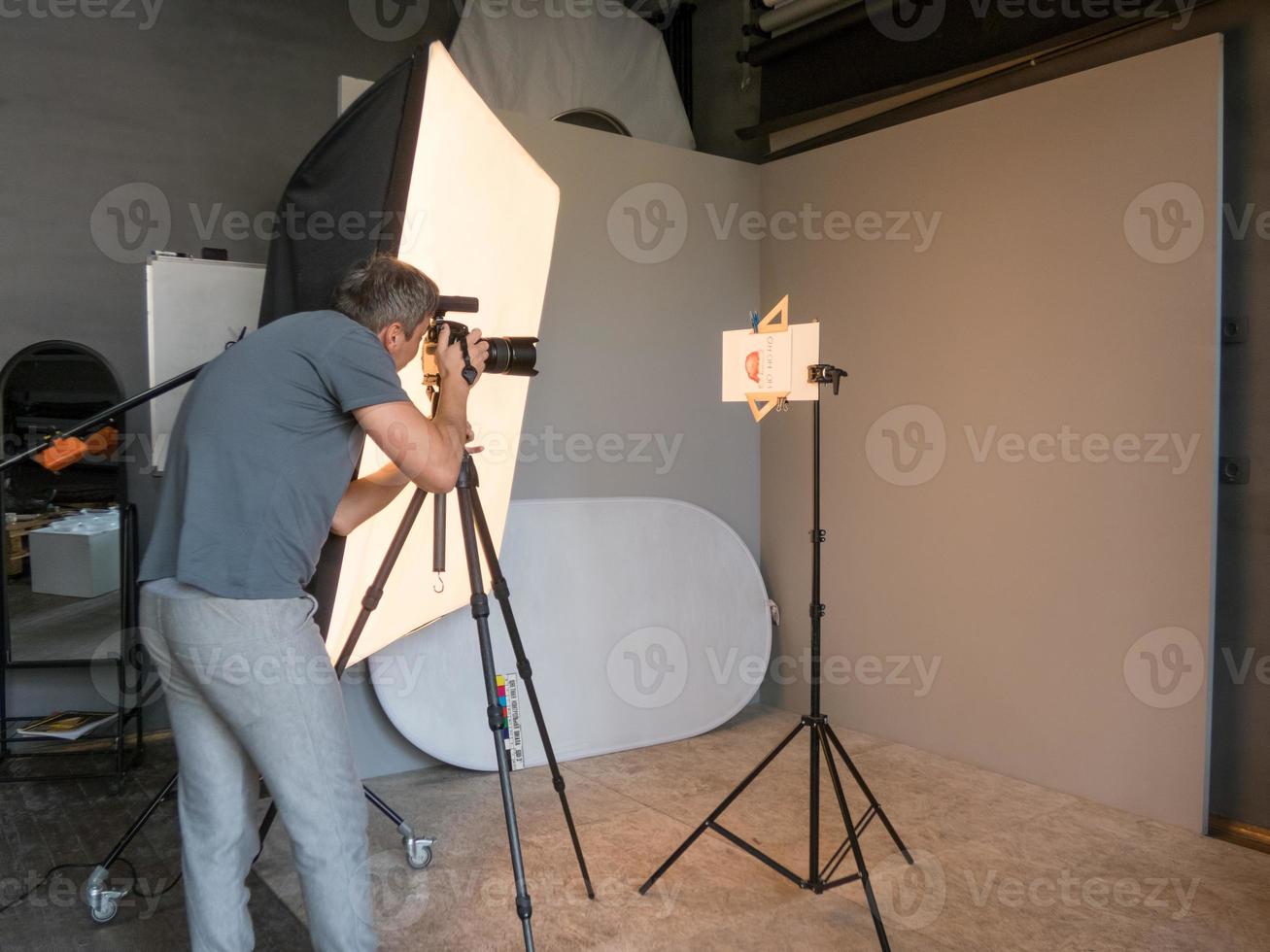 junger Mann, der im Fotostudio arbeitet. unbeabsichtigtes Fotografieren foto