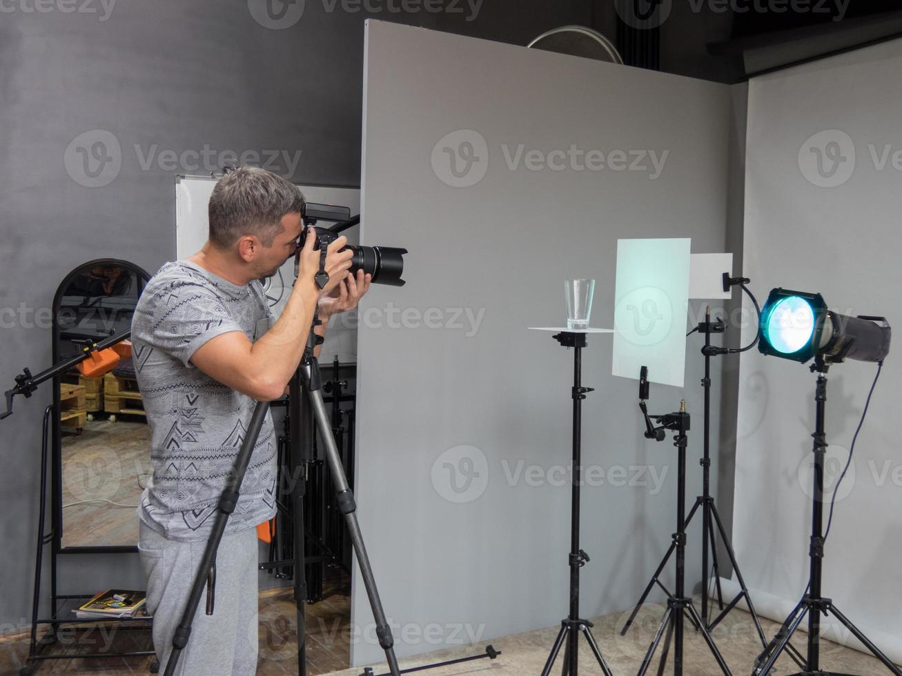 ein junger Fotograf, der gerade in einem Fotostudio arbeitet. unbeabsichtigtes Fotografieren foto