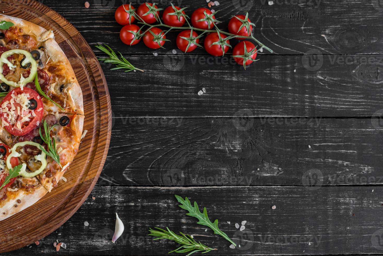 traditionelle italienische pizza, gemüse, zutaten auf dunklem hintergrund foto