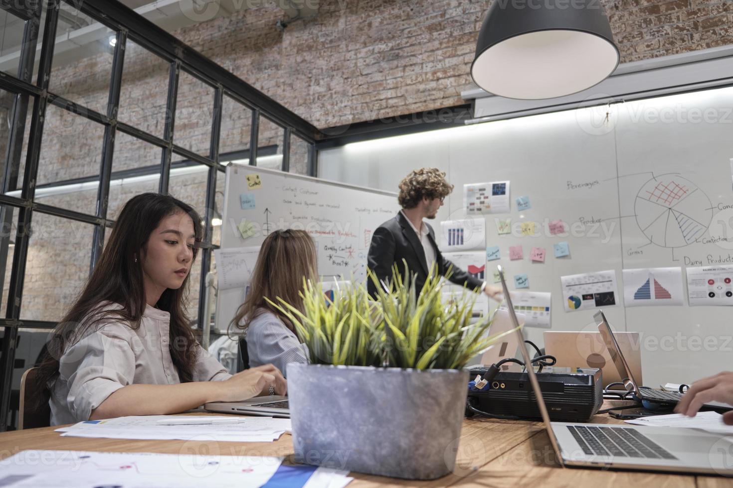 Treffen eines professionellen Teams, kluger Kollegen und Mitarbeiter, Brainstorming und Präsentation im Konferenzraum des Geschäftsbüros mit einem kaukasischen männlichen Manager, Diskussion über Finanzen und Marketing. foto