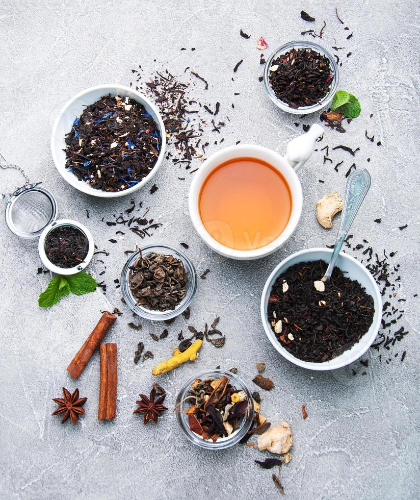 Tasse Tee mit aromatischem Trockentee in Schalen foto