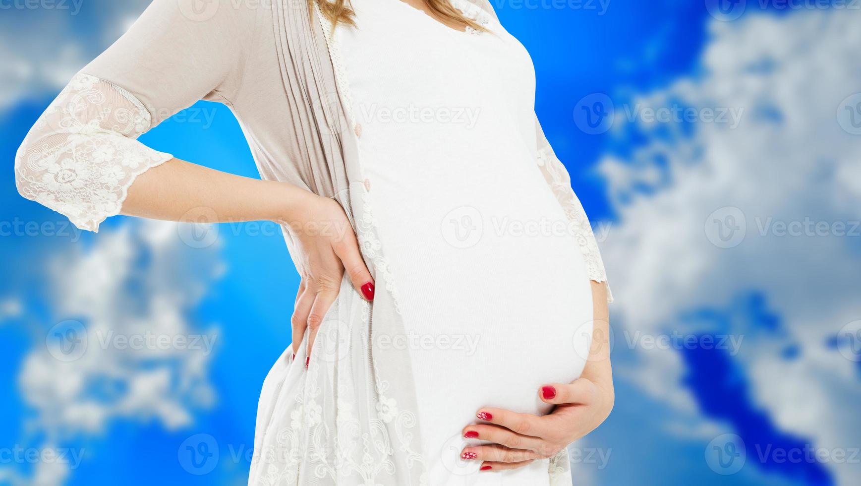 schwangere Frau in Freizeitkleidung isoliert auf verschwommenem Himmelshintergrund, schwangere Frau in Freizeitkleidung isoliert auf blauem Hintergrund, schwangere schöne Dame, die ein Baby erwartet foto