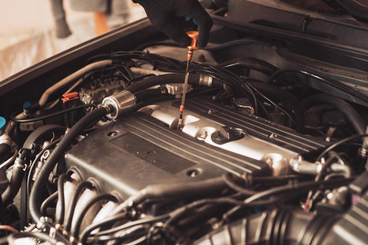 automechaniker repariert auto. Der Mitarbeiter führt die Wartung der Maschine durch. foto