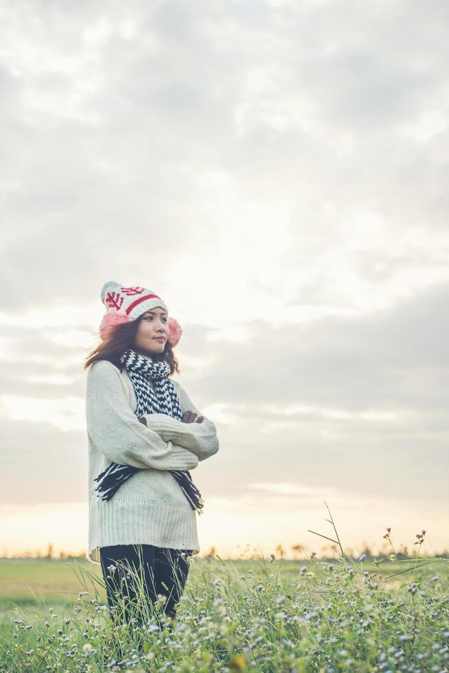 junge schöne frau, die winterkleidung trägt, während sie steht, genießt mit der natur. Winterzeit-Konzept. foto