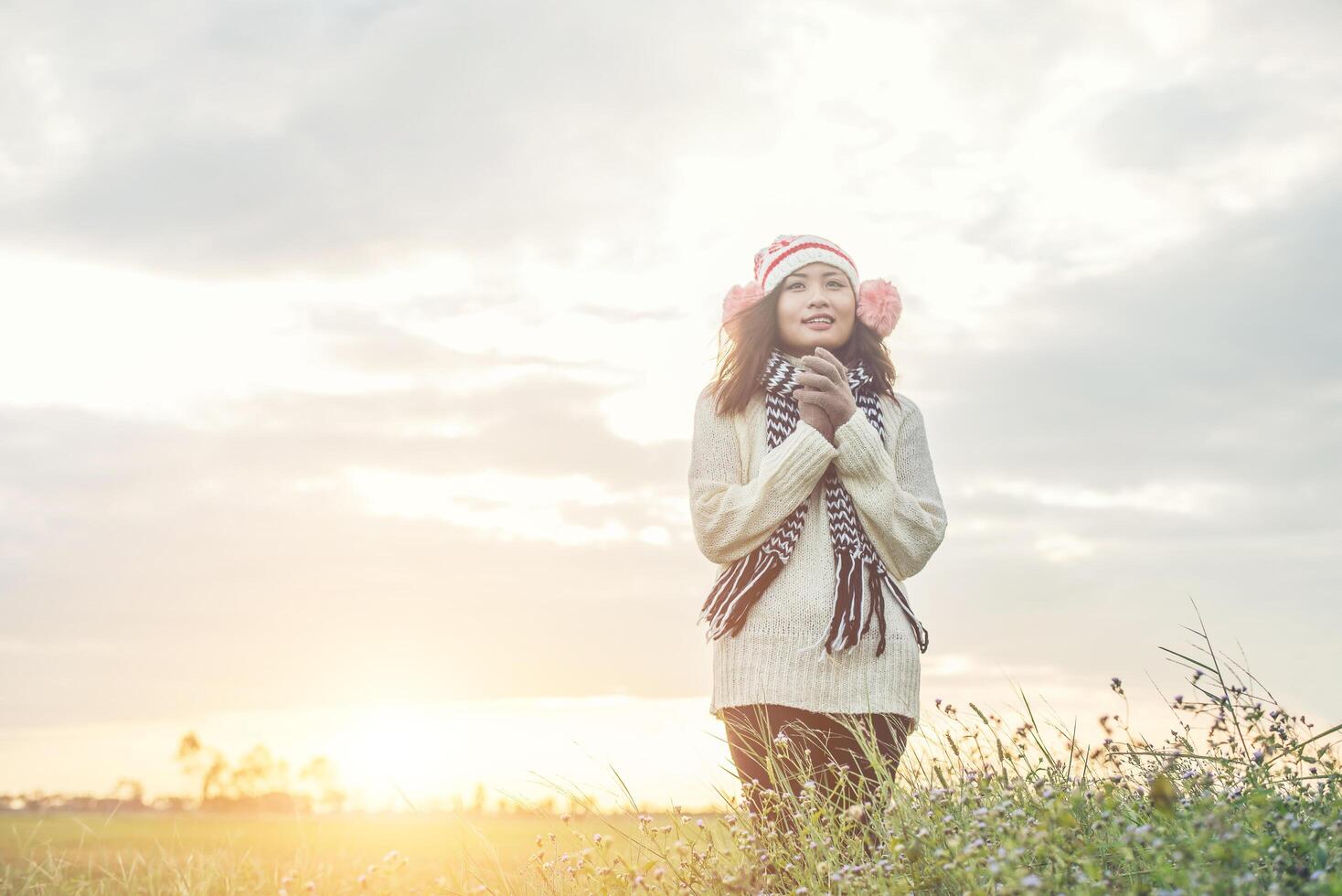 junge schöne frau, die winterkleidung trägt, während sie steht, genießt mit der natur. Winterzeit-Konzept. foto