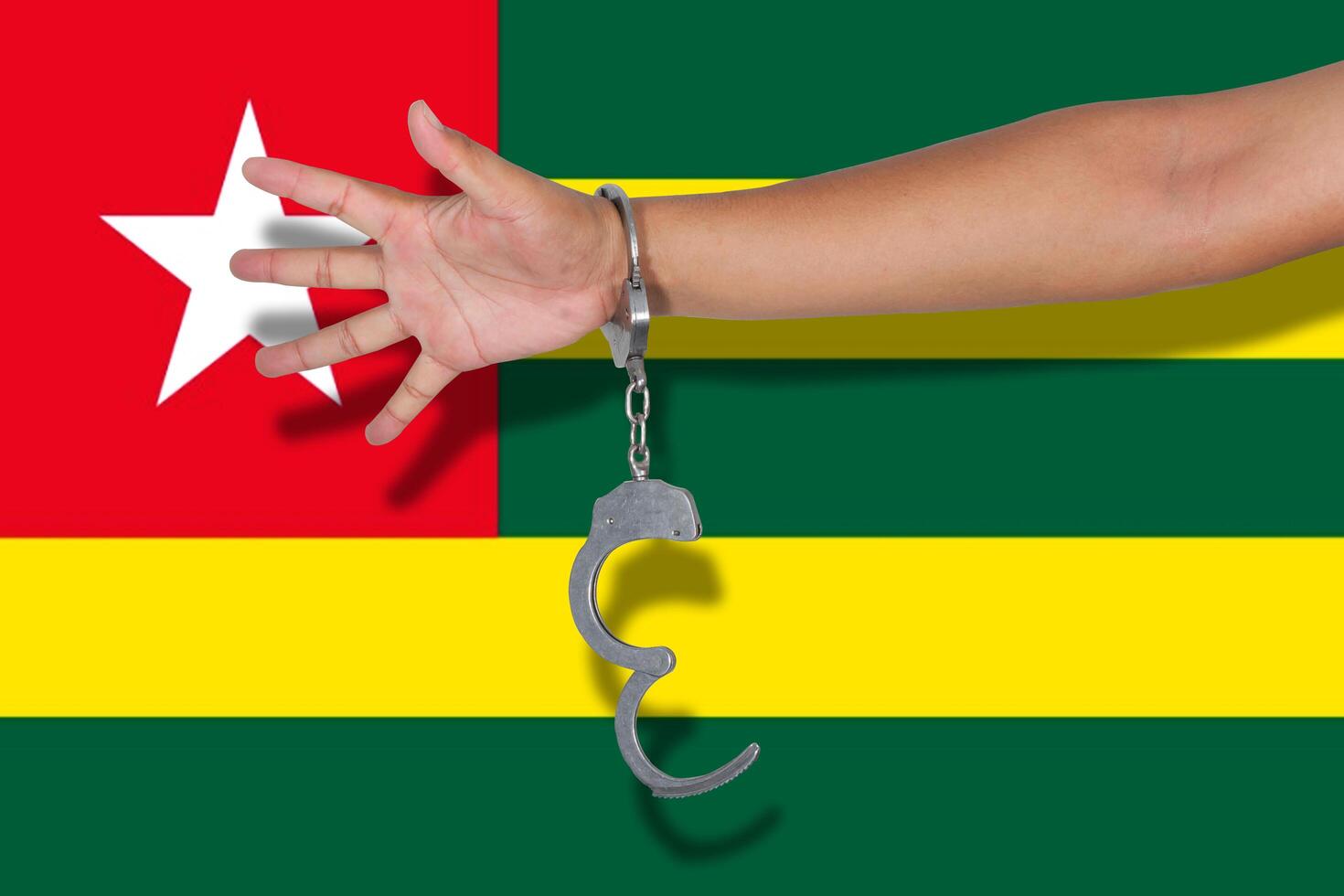 Handschellen mit Hand auf Togo-Flagge foto