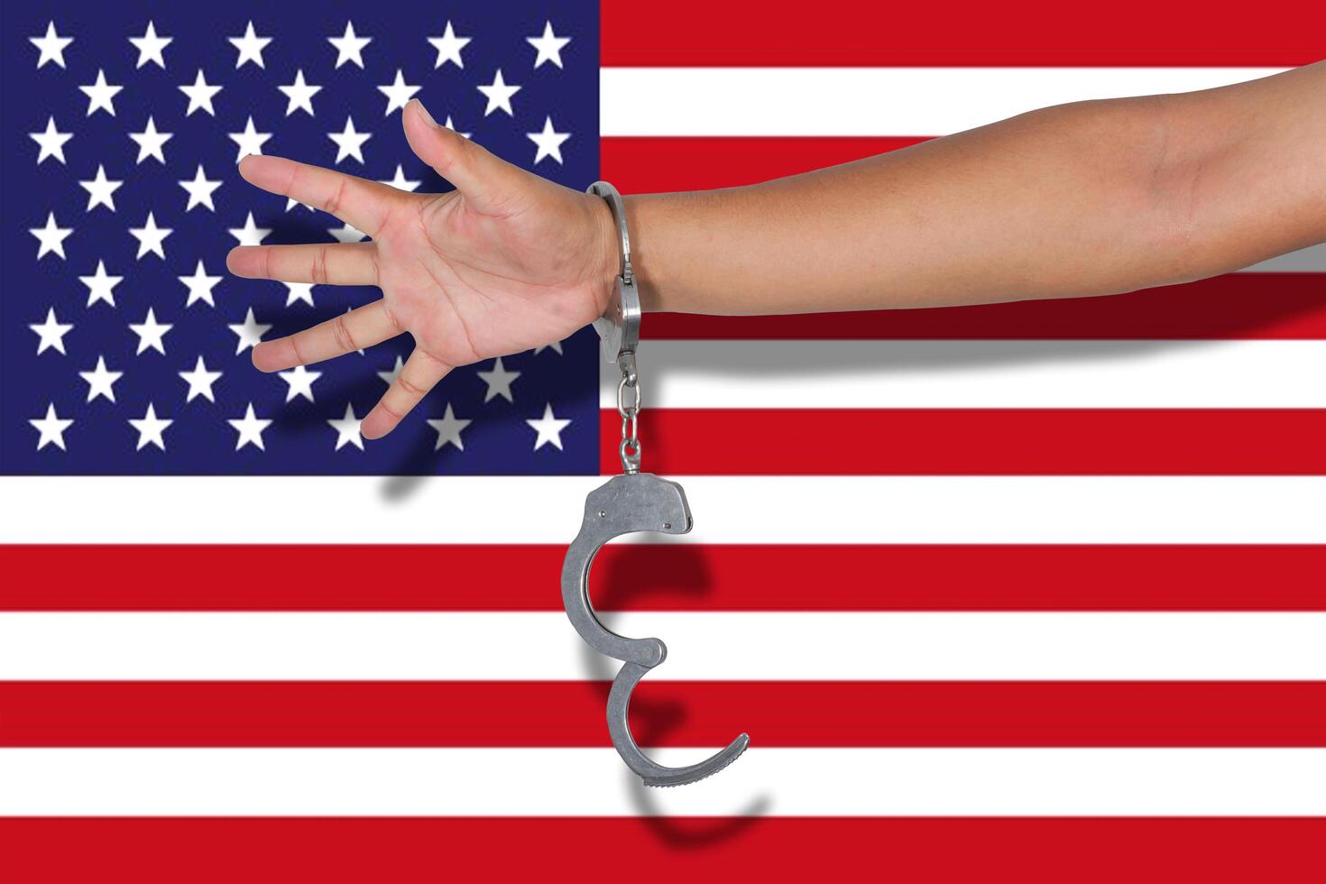 Handschellen mit der Hand auf der amerikanischen Flagge foto