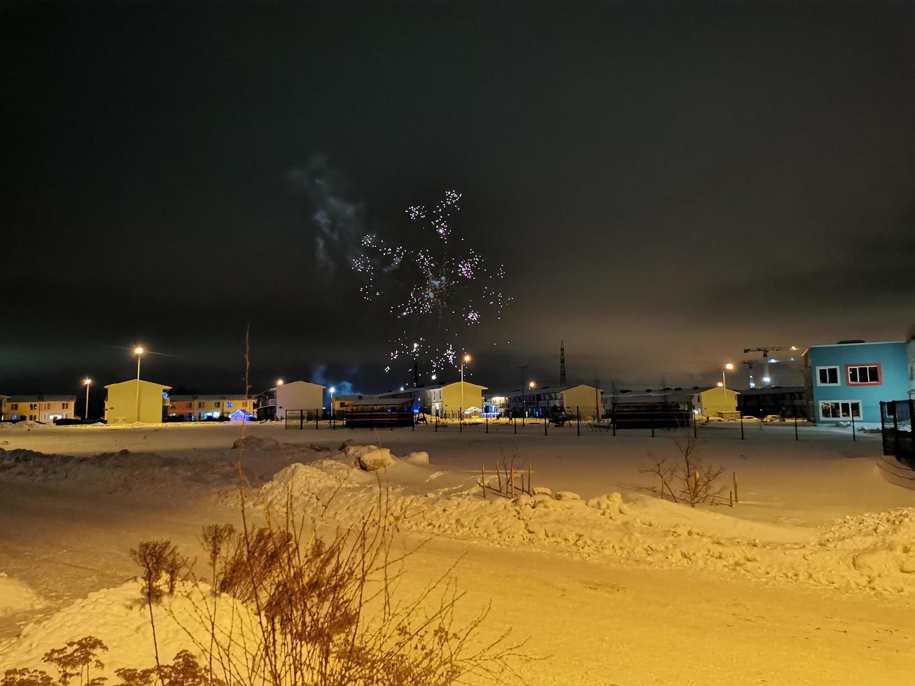 Neujahrsfeuerwerk im Hüttendorf in einer Winternacht foto