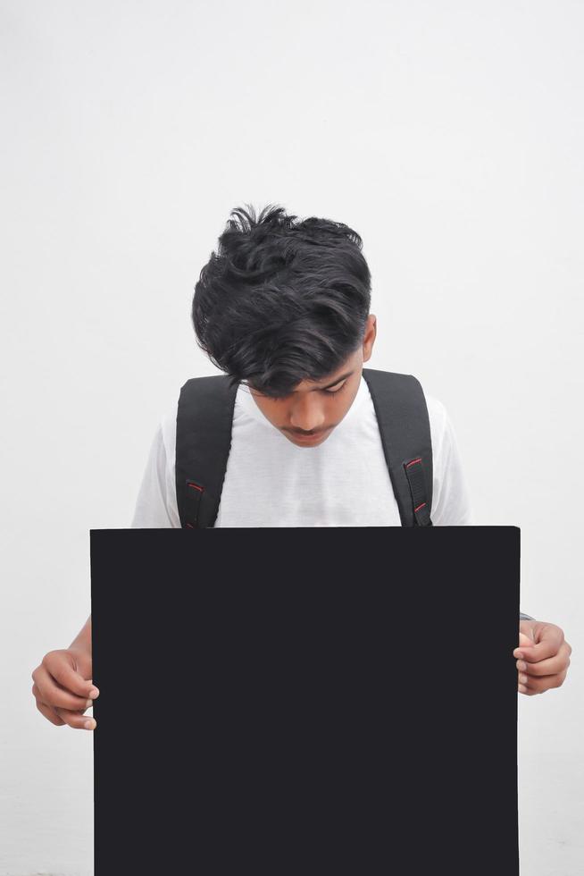 Indischer College-Student, der Brett auf weißem Hintergrund zeigt. foto