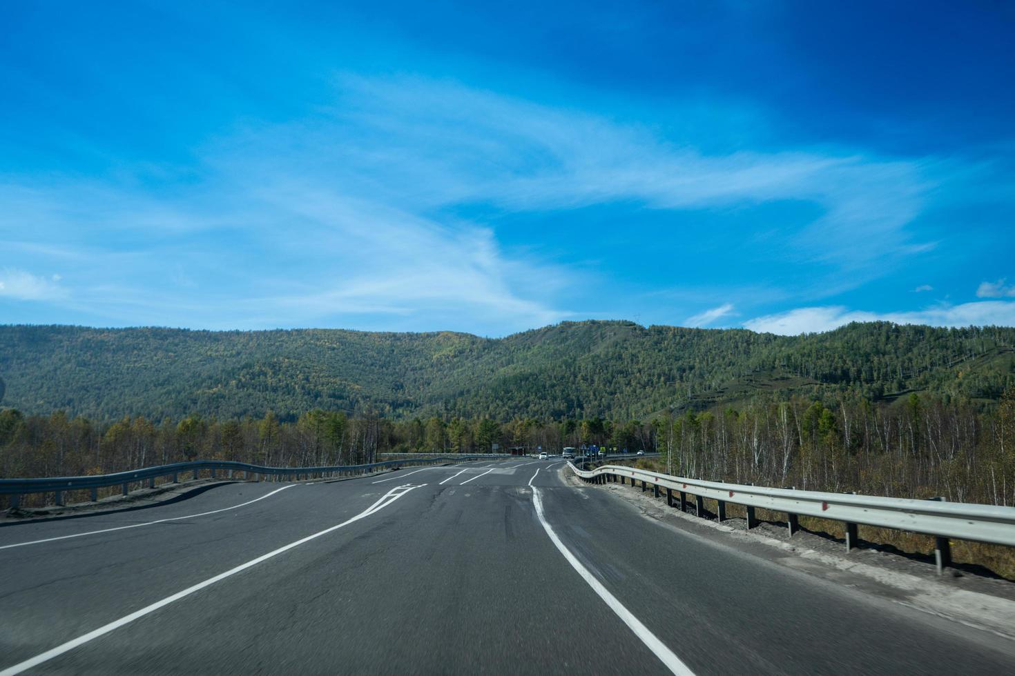 eine Landschaft mit einer kurvenreichen Autobahn unter einem bewölkten Himmel. foto