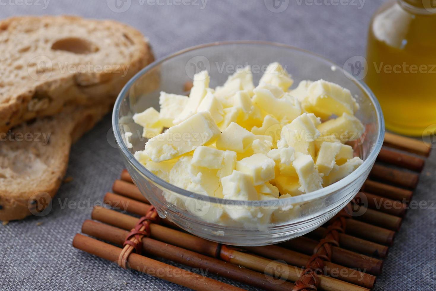 frische Butter in einem Behälter mit Brot auf weißem Hintergrund foto