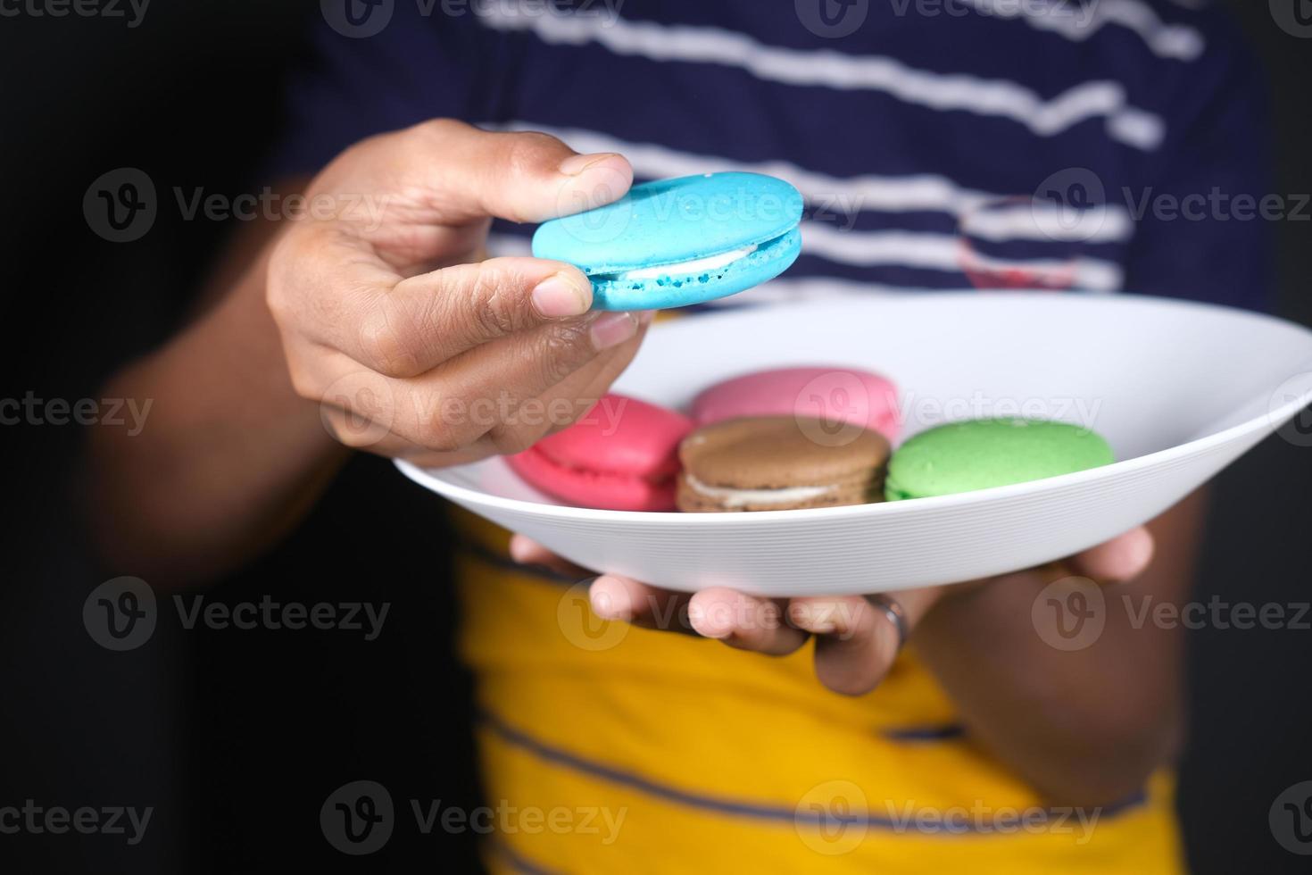 Nahaufnahme von Makronen von Hand pflücken foto