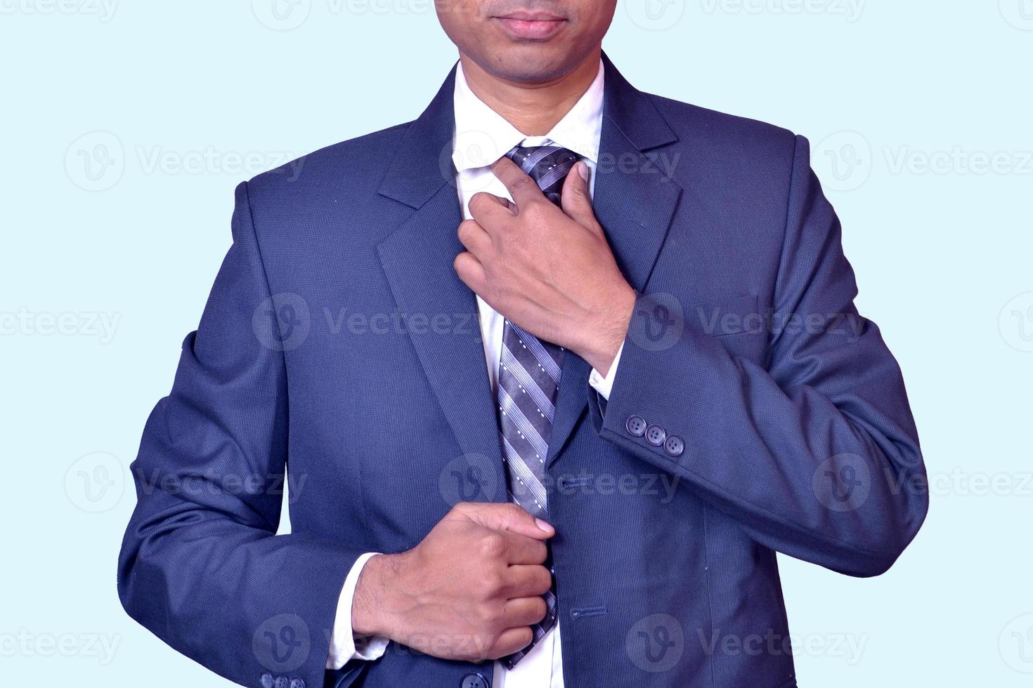 indischer junger geschäftsmann, der sein krawattenbild hält foto