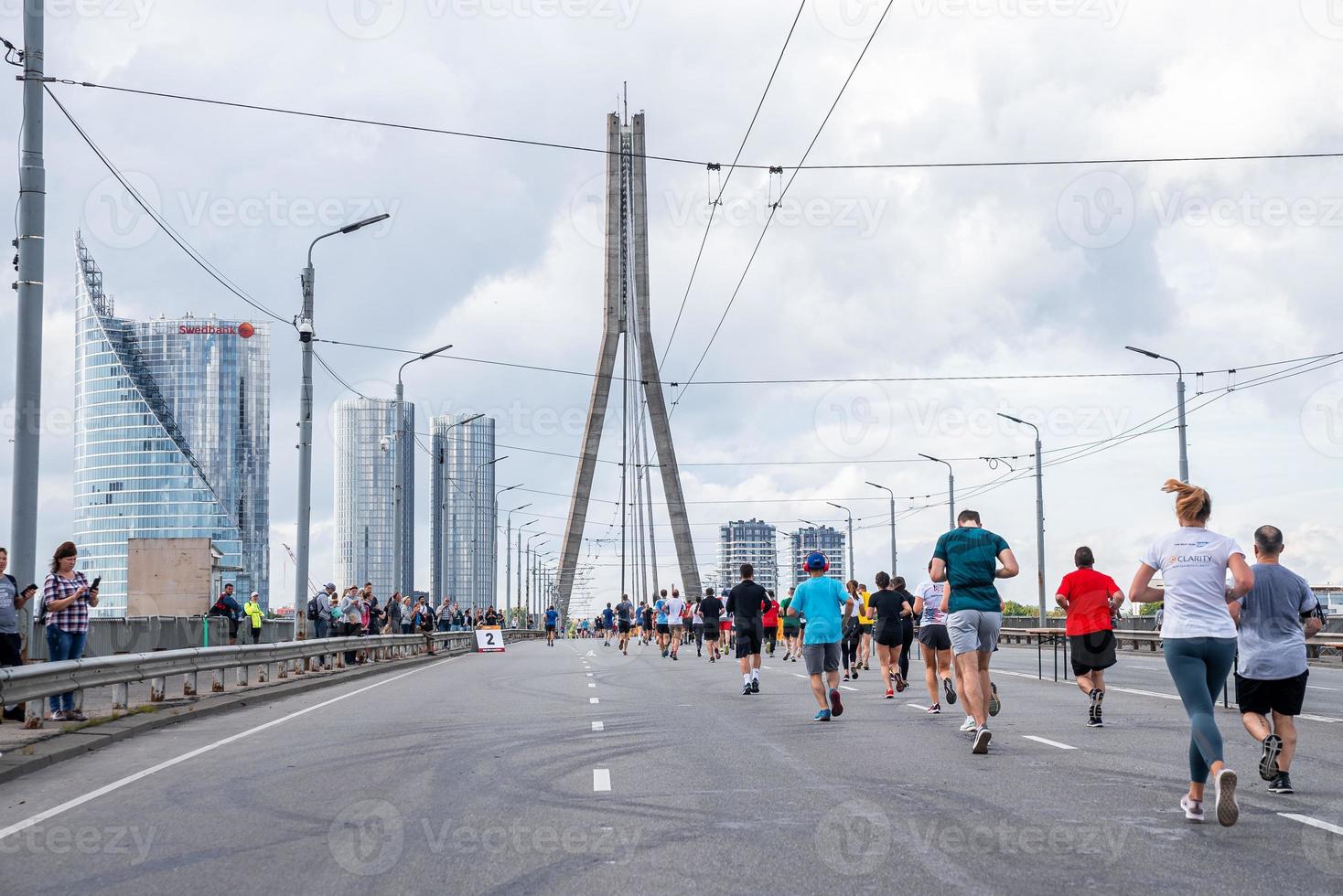 läufer, die während des tet riga marathons die straßen von riga überqueren. foto