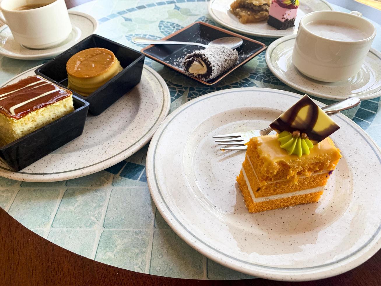 verschiedene farbige Kuchen auf Tellern. süße Desserts. Studiofoto foto