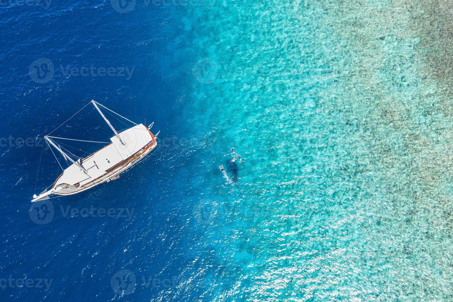 Jachtankern in kristallklarem türkisfarbenem Wasser vor der tropischen Insel, Freizeitlebensstil, Schnorcheln. luftaufnahme der yacht vor anker auf türkisfarbenem wasser, luxusaktivität, malediven-tour foto