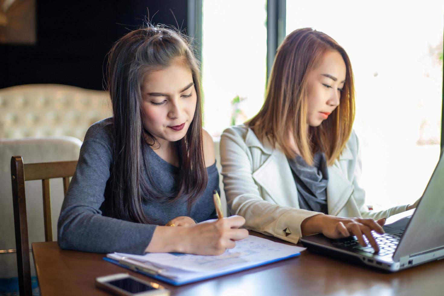 zwei asiatische geschäftsfrauen mit notebook arbeiten und besprechen des wichtigen vertrags im büro foto