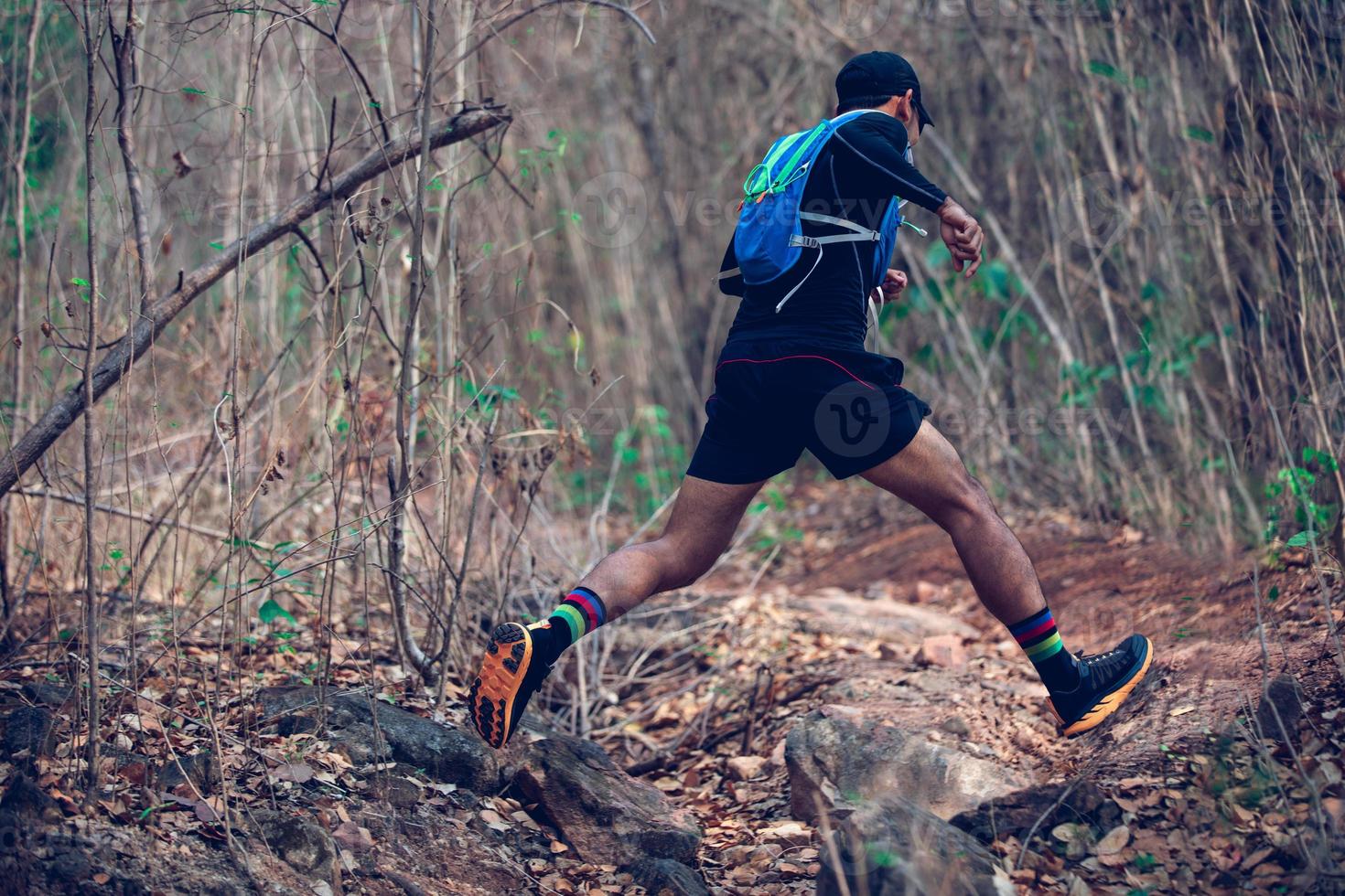 ein Mann Läufer der Spur. und die Füße des Athleten, die Sportschuhe für Trailrunning im Wald tragen foto