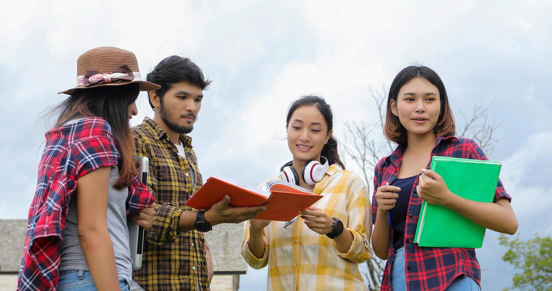 Gruppenschüler lächeln und haben Spaß. Es hilft auch, Ideen in der Arbeit und im Projekt zu teilen. und rezensieren Sie das Buch auch vor der Prüfung im Freien im Garten. foto