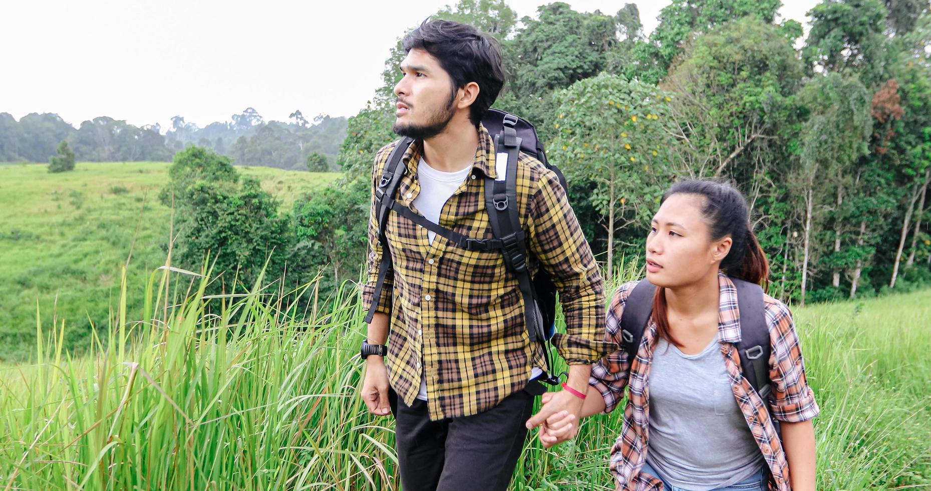 Asiatische Gruppe junger Leute, die mit Freunden wandern, Rucksäcke, die zusammen spazieren gehen und eine Karte suchen und eine Fotokamera an der Straße machen und glücklich aussehen, entspannen Sie sich bei Urlaubskonzeptreisen foto